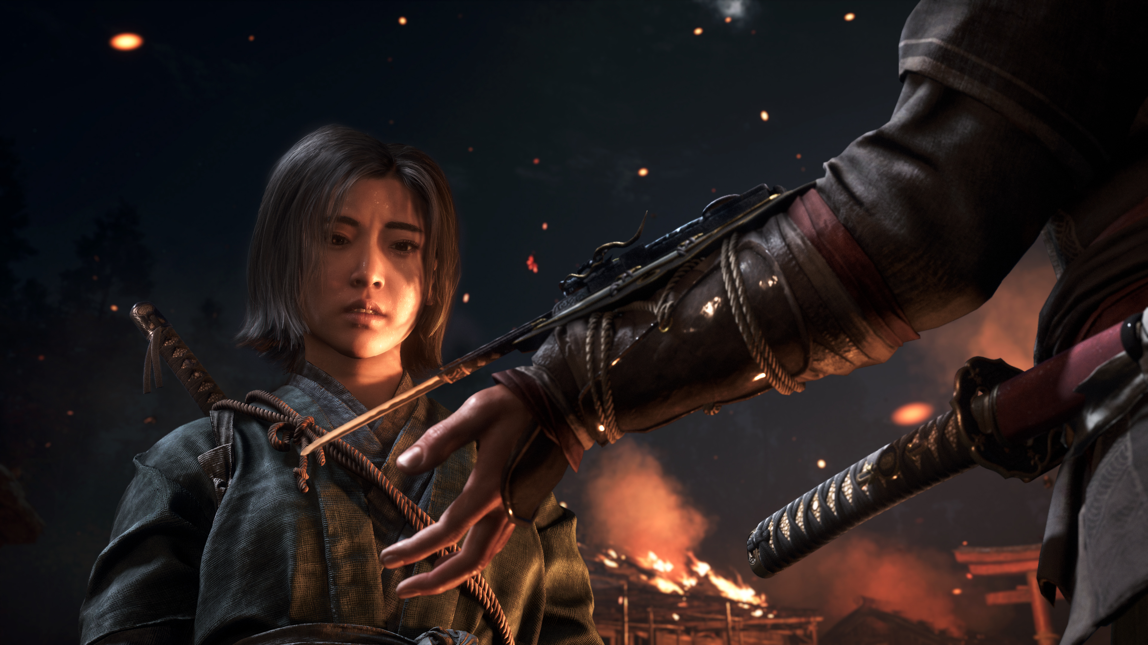 Naoe, a young Japanese woman, looks down in surprise as someone demonstrates the Assassins’ hidden blade in Assassin’s Creed Shadows