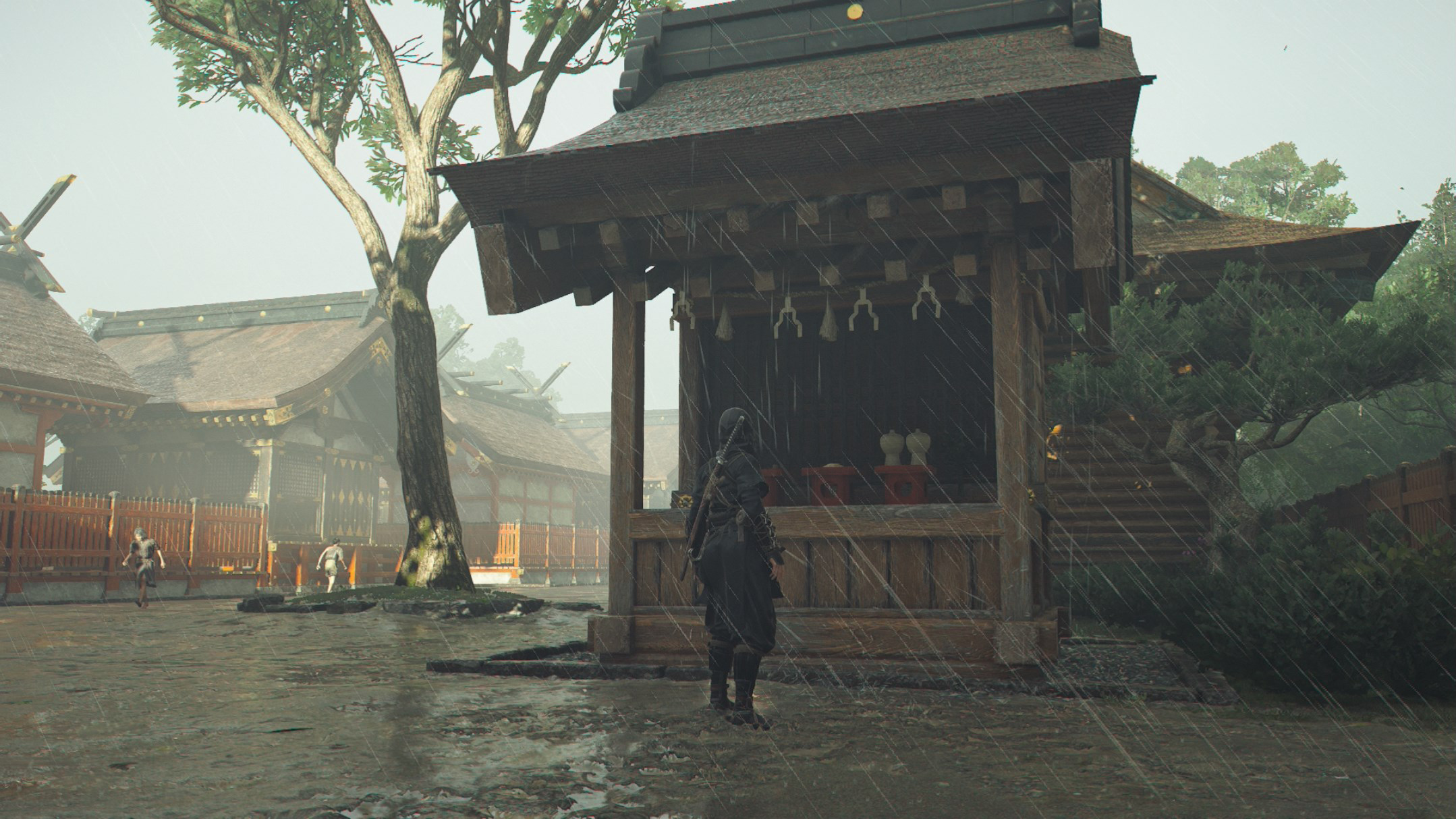 Naoe stands in front of a shrine in the rain in Assassin’s Creed Shadows.