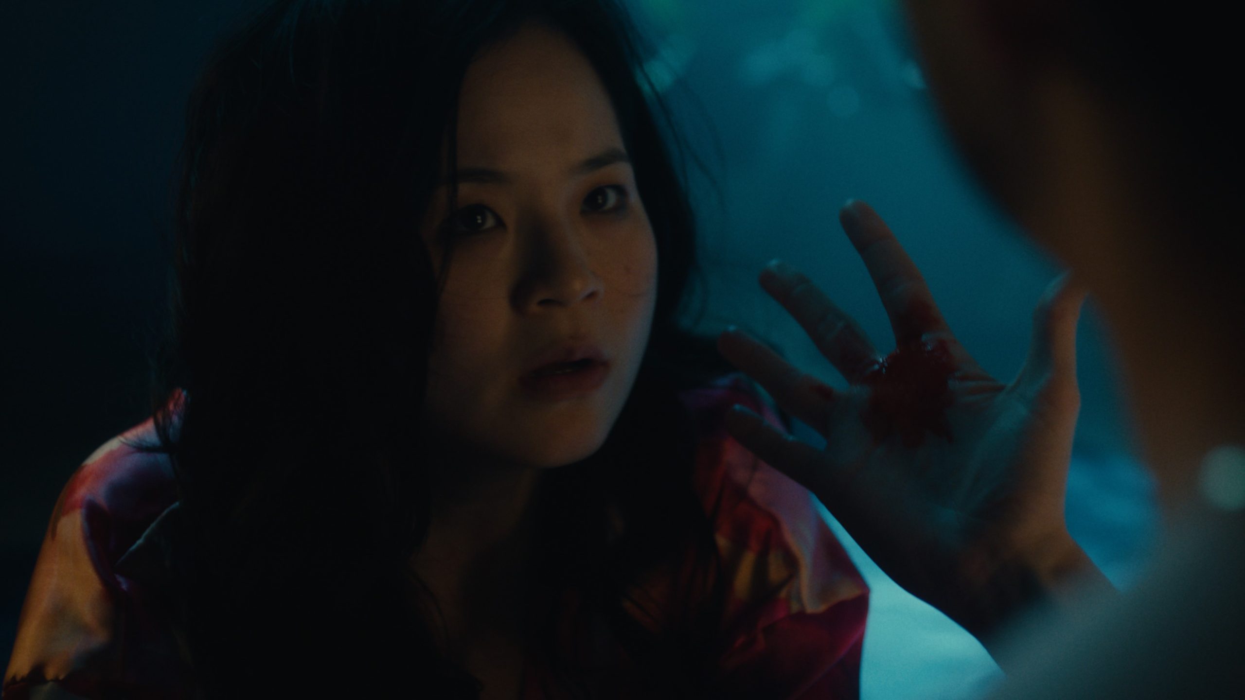 Kelly Marie Tran looks shocked while a man in the foreground shows her his bloody hand in Control Freak