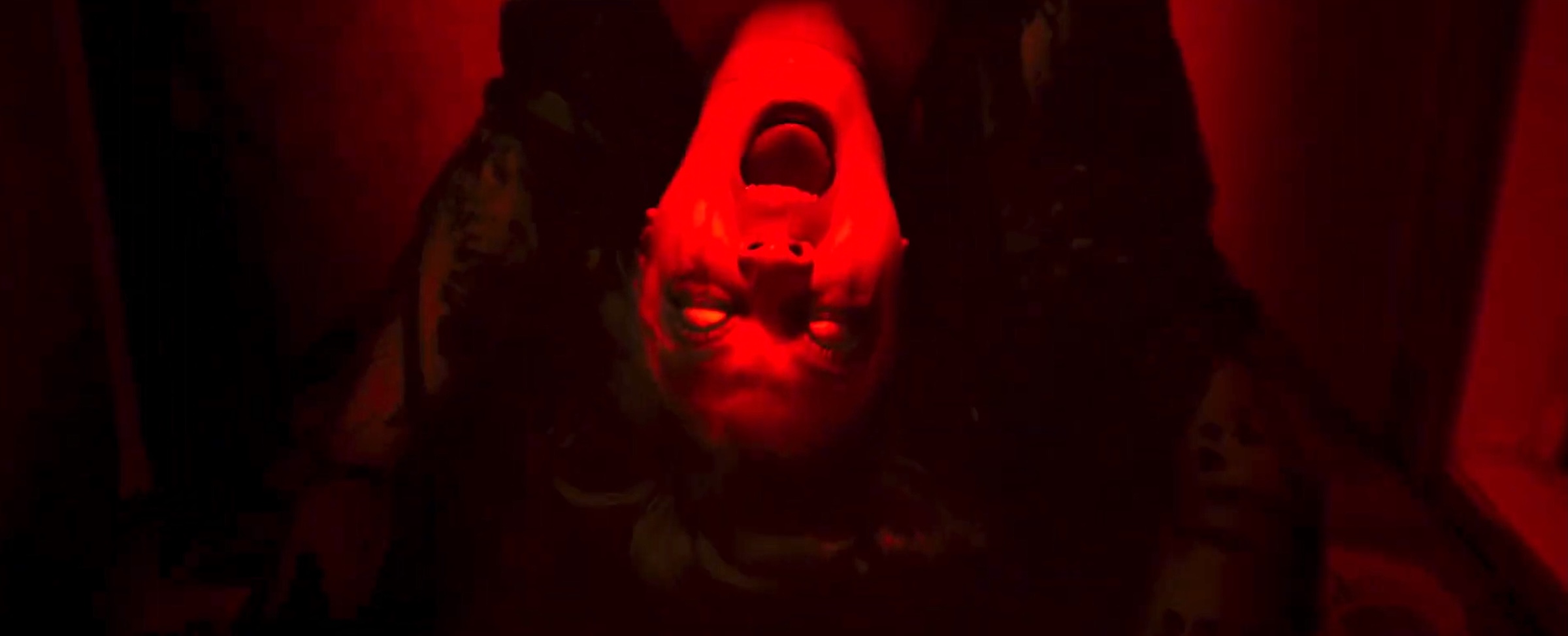 Urban legend ghost Catherine (Sandrine Pinna) does a backbend, screaming and white-eyed, in a red-tinted hotel room to scare off a guest in Dead Talents Society