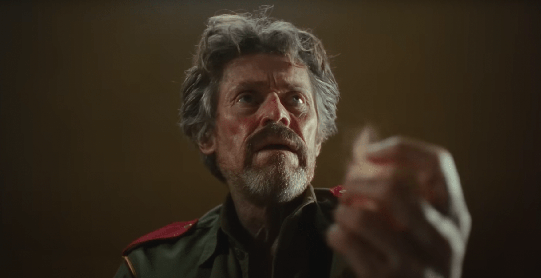 Willem Dafoe holding a piece of bloody fur in his hand in The Legend of Ochi