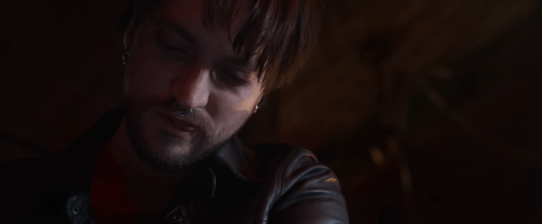 Richard Harmon in Final Destination Bloodlines with a nose piercing looking down intently at something