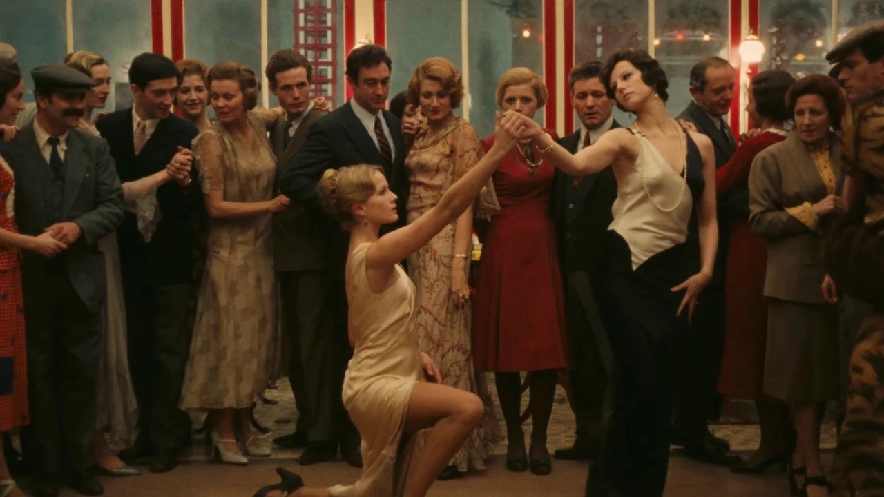Two women dancing in the middle of a crowd in The Conformist.