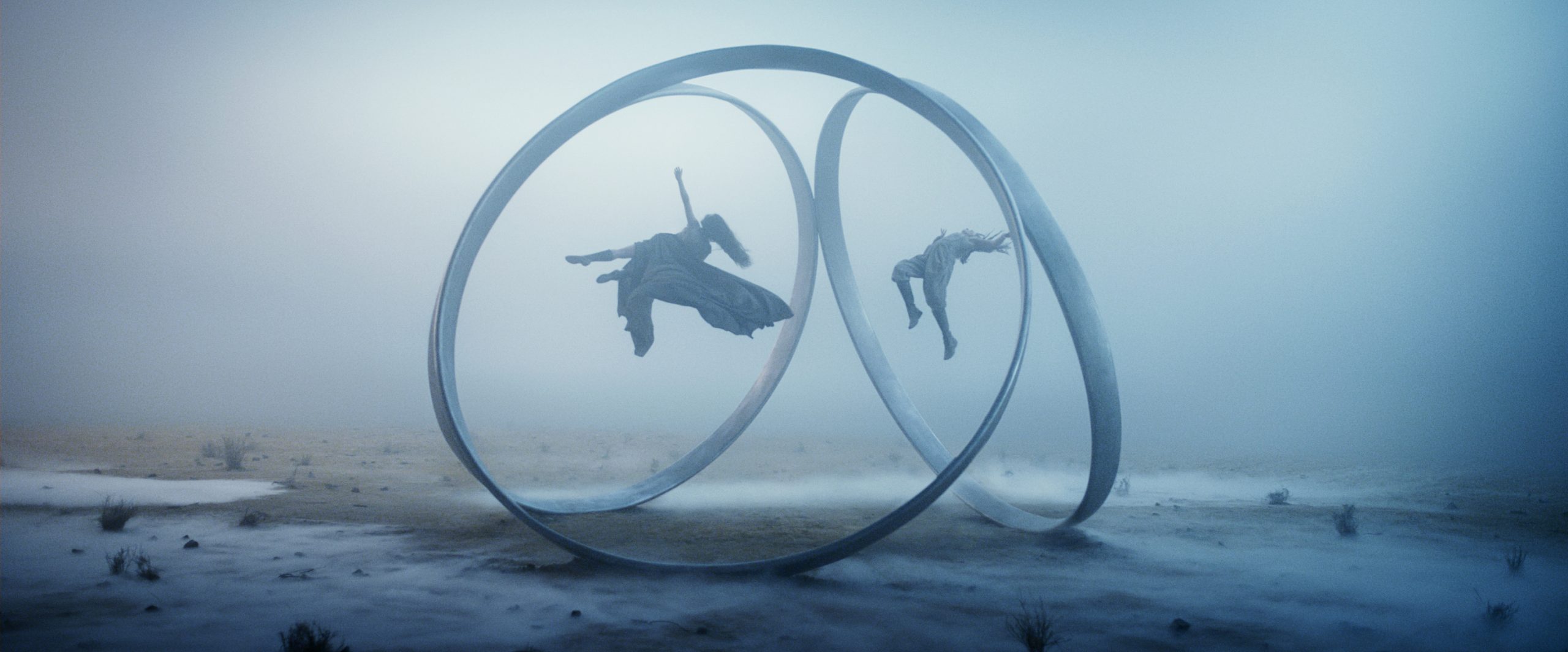 Rosamund Pike (as Moiraine) and Ayoola Smart ( as Aviendha) being suspended in portal rings in a still from Wheel of Time season 3
