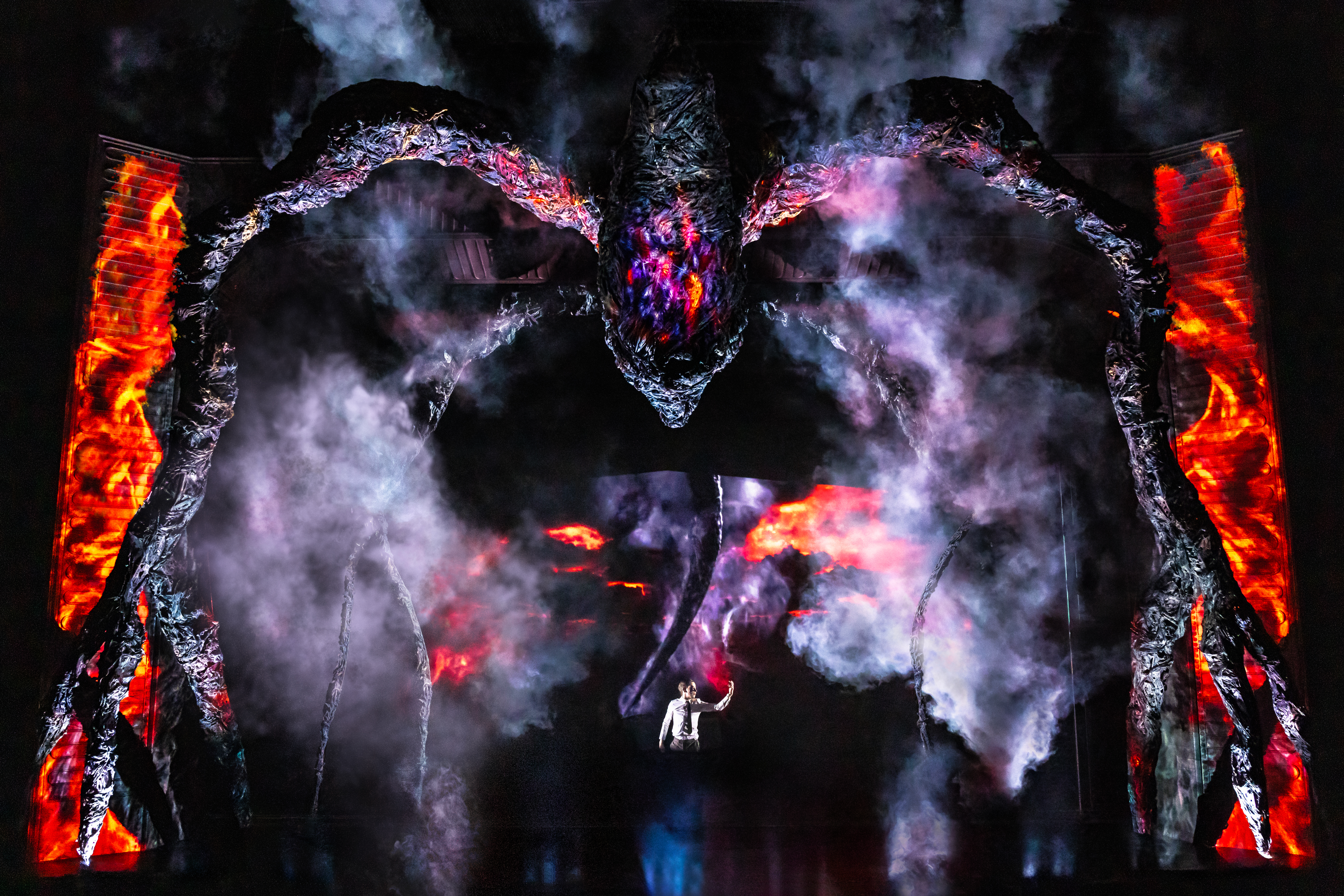 Henry Creel (Louis McCartney) on stage under the Mind Flayer in a stage image from Stranger Things: The First Shadow