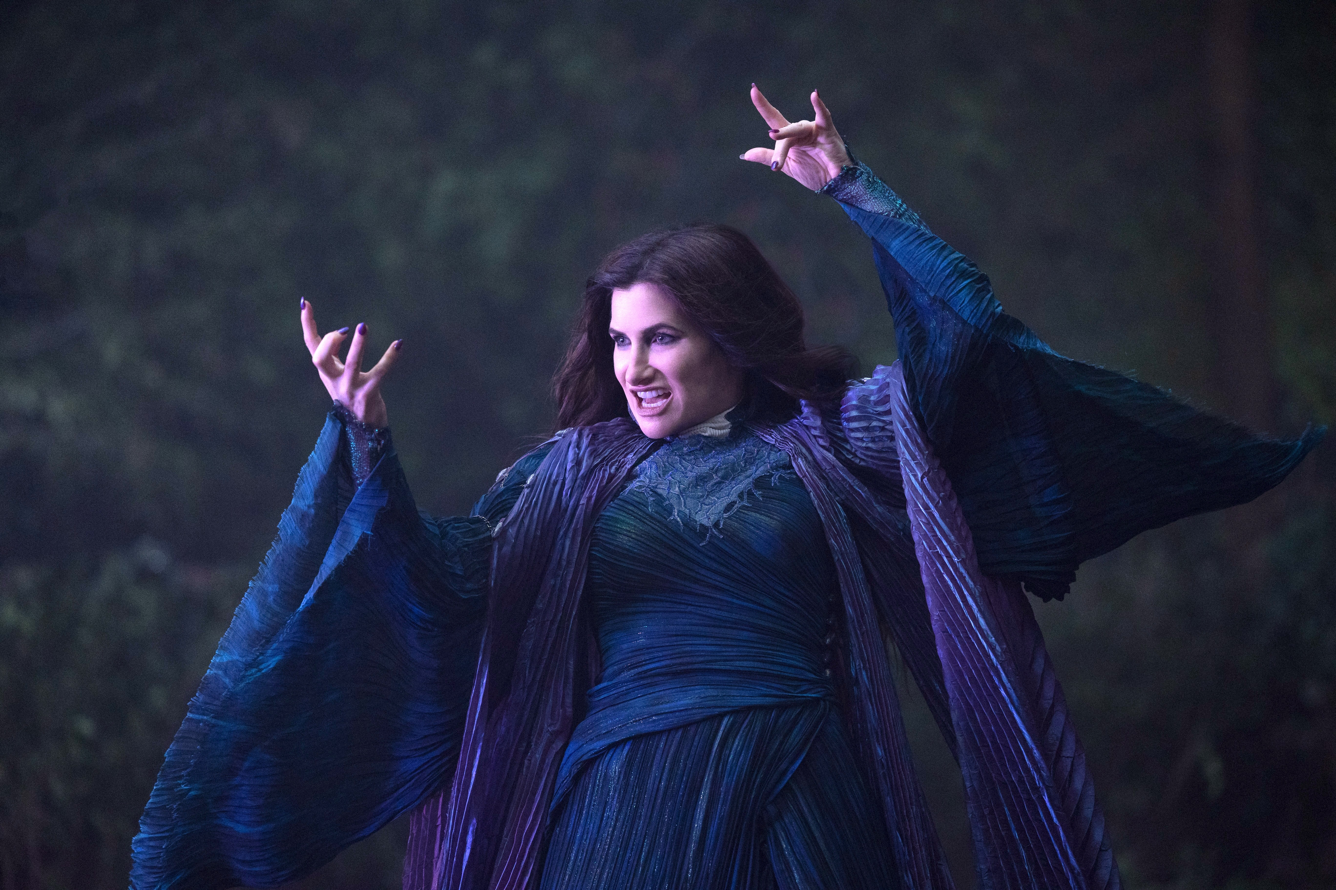 Agatha Harkness (Kathryn Hahn) raises her arms as if to cast a curse in Agatha All Along.