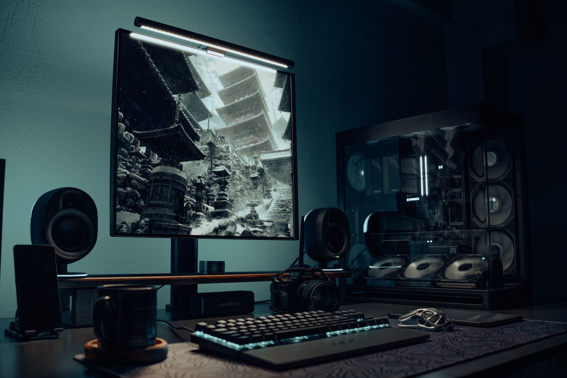 A PC gaming setup with keyboard and monitor glowing in a dark room